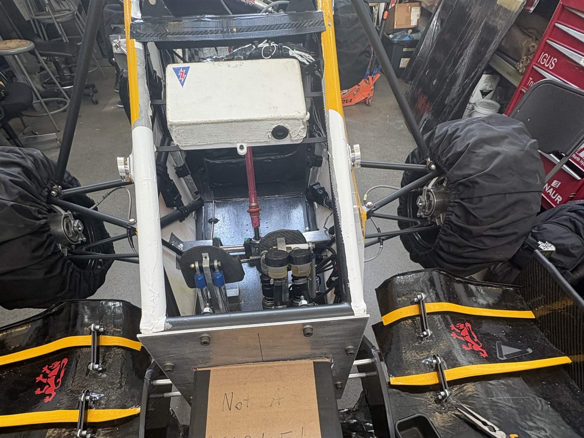 Formula Electric car cockpit and front suspension in the team bay